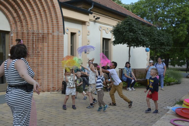 Gyermekek körben állva vidáman játszanak a Bohóc Angol szabadtéri foglalkozásán